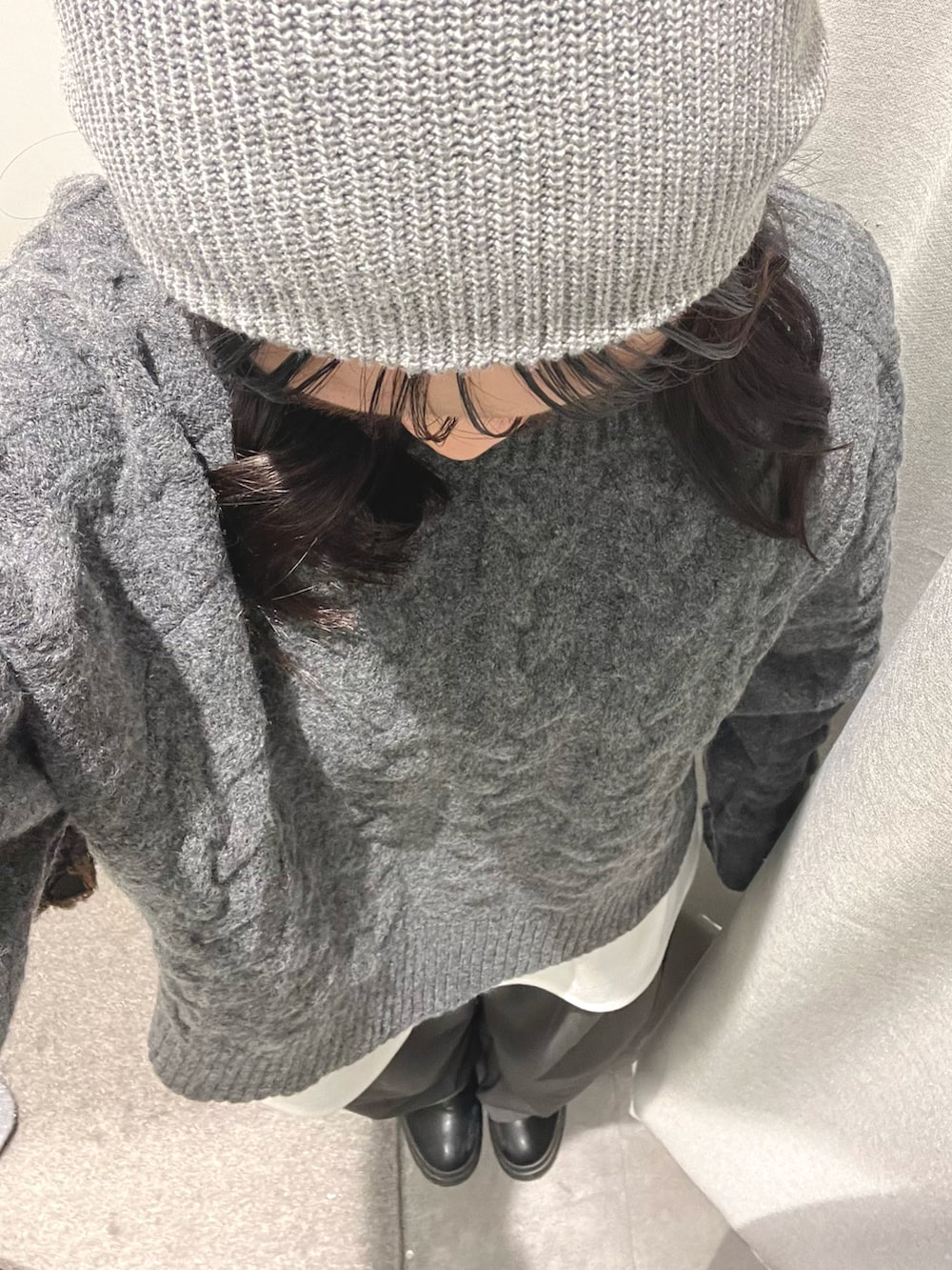 ホワイト系のTシャツ/カットソー、グレー系のスラックス、グレー系のニット/セーターを着用したレディースの冬コーディネートの2枚目の写真