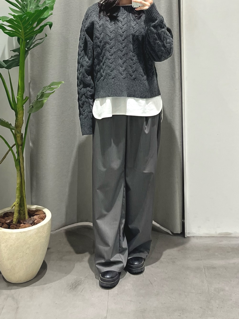 ホワイト系のTシャツ/カットソー、グレー系のスラックス、グレー系のニット/セーターを着用したレディースの冬コーディネートの3枚目の写真