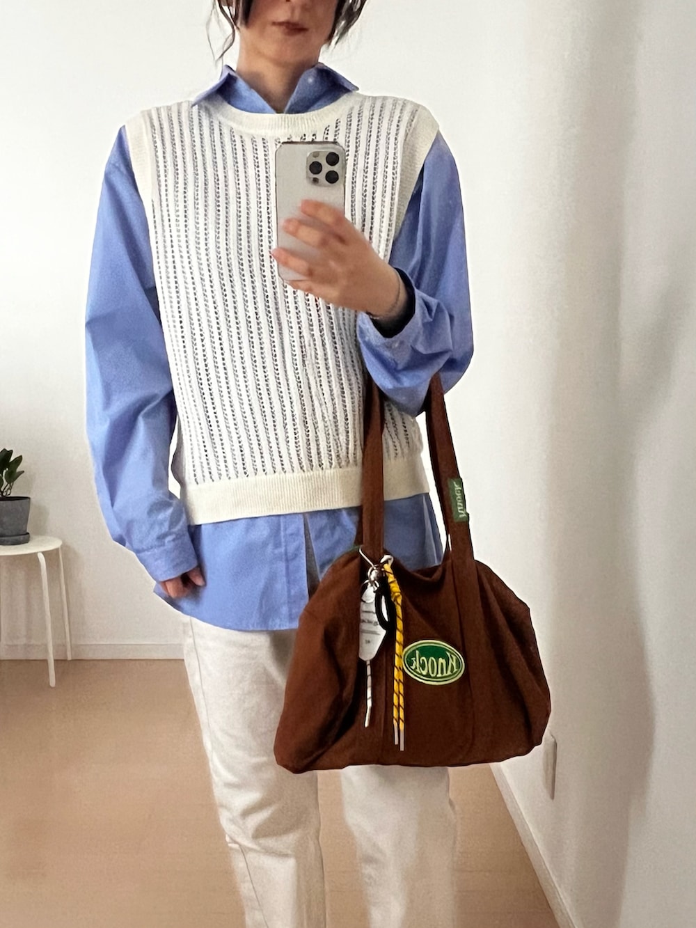 ホワイト系のベスト、ブルー系のシャツ/ブラウス、ホワイト系のデニムパンツを着用したレディースの春コーディネートの2枚目の写真