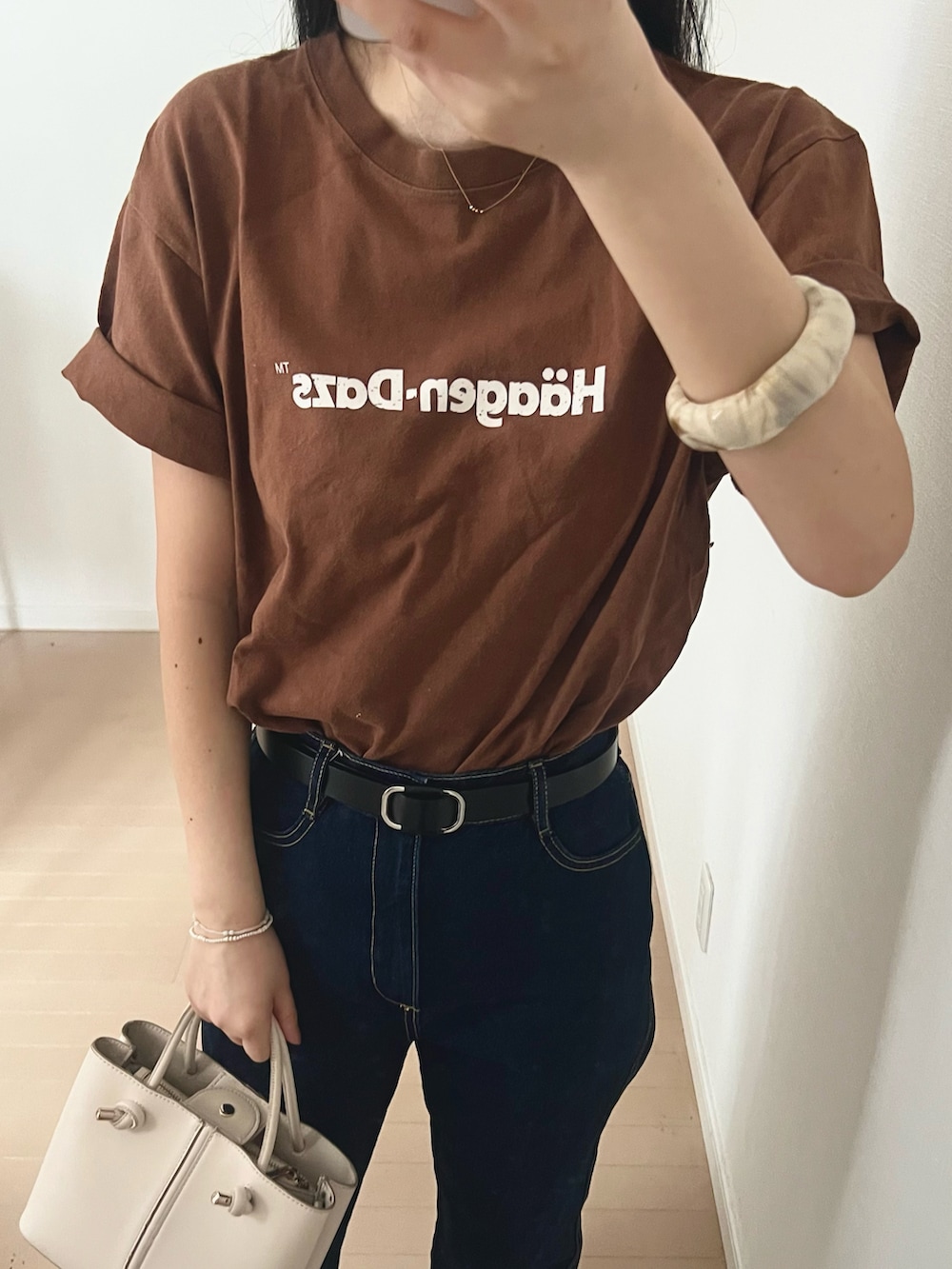 ブラウン系のTシャツ/カットソー、ブルー系のデニムパンツ、ブラック系のサンダルを着用したレディースの春コーディネートの2枚目の写真