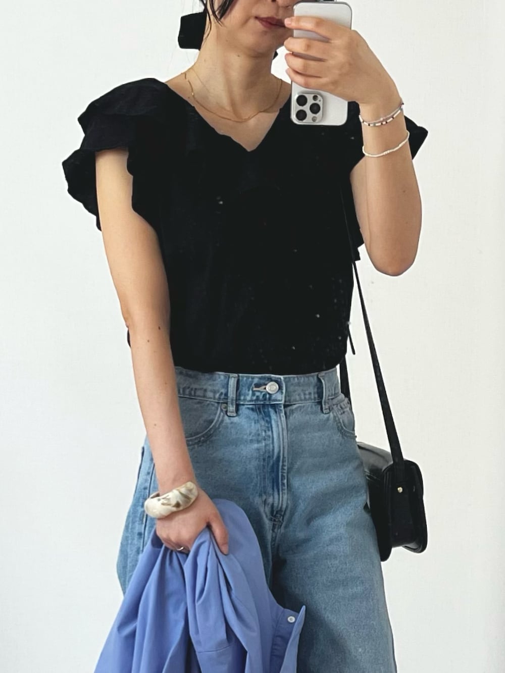 ブラック系のTシャツ/カットソー、ブルー系のシャツ/ブラウス、ブルー系のデニムパンツを着用したレディースの春コーディネートの2枚目の写真