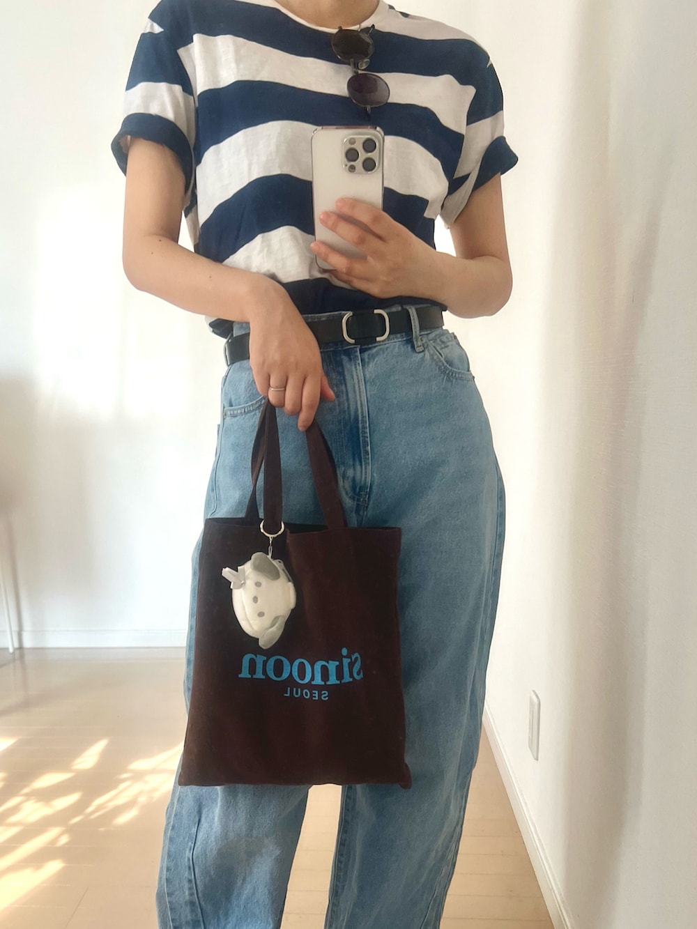 ブルー系のTシャツ/カットソー、ブルー系のデニムパンツ、ブラウン系のエコバッグ/サブバッグを着用したレディースの夏コーディネートの2枚目の写真