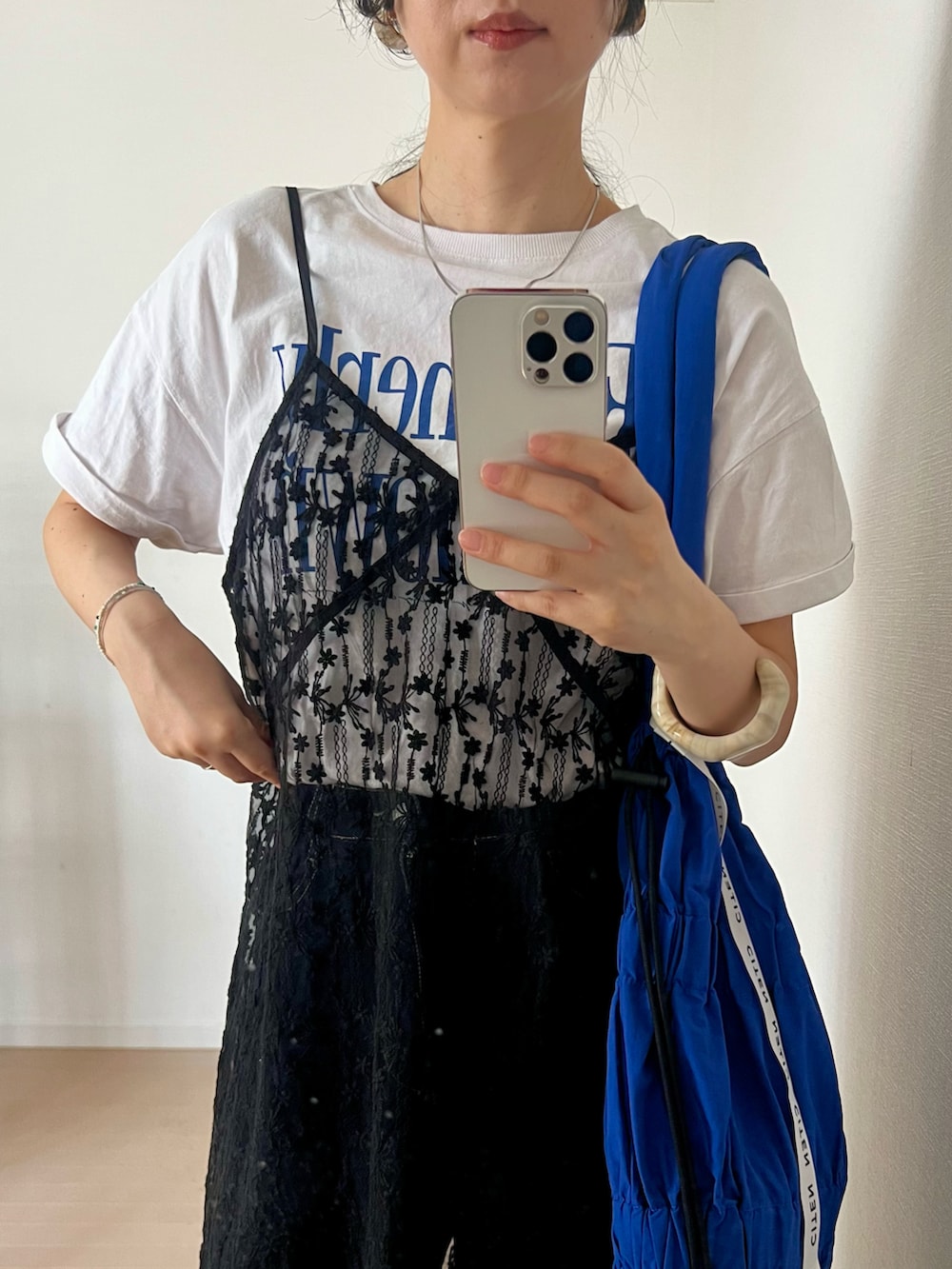 ブラック系のサンダル、ホワイト系のTシャツ/カットソー、ブルー系のデニムパンツを着用したレディースの春コーディネートの2枚目の写真