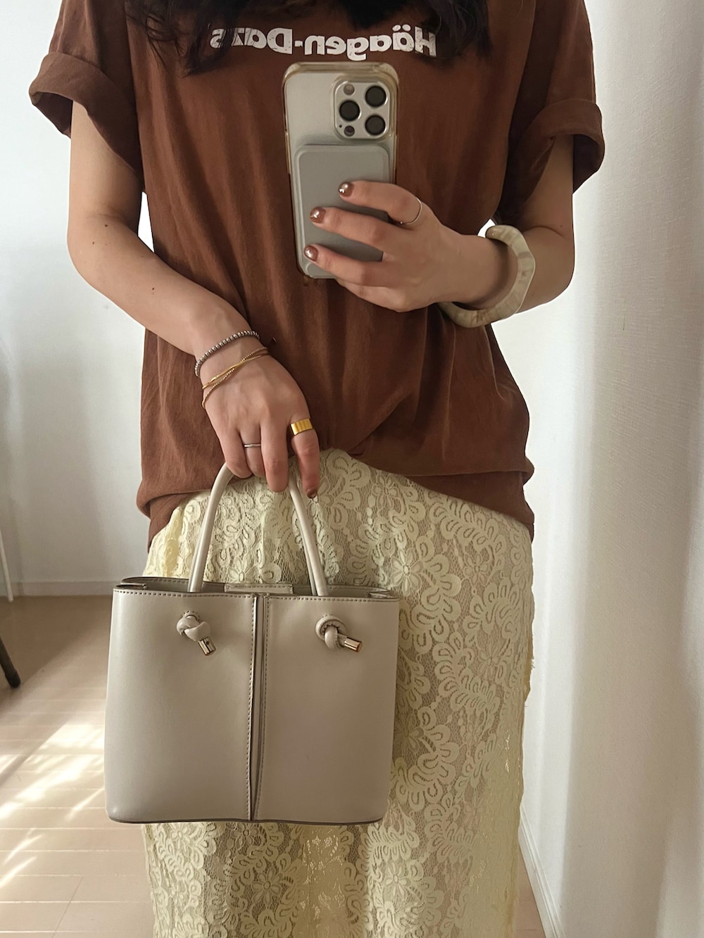 ブラウン系のTシャツ/カットソー、ホワイト系のハンドバッグ、ホワイト系のパンツを着用したレディースの夏コーディネートの2枚目の写真