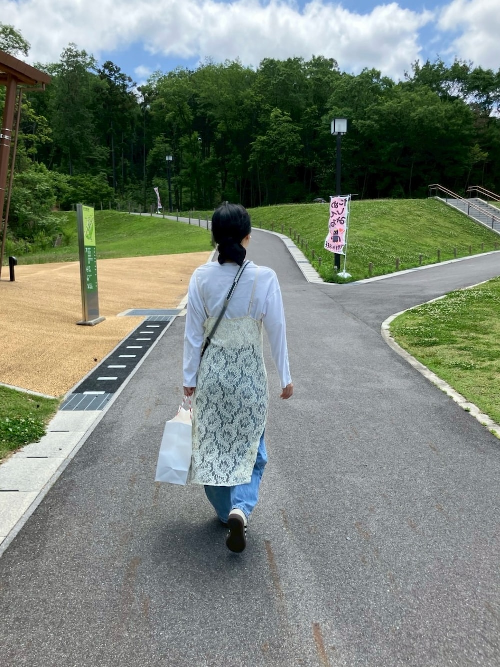 ブルー系のデニムパンツ、ホワイト系のスニーカー、ホワイト系のTシャツ/カットソーを着用したレディースの春コーディネートの2枚目の写真