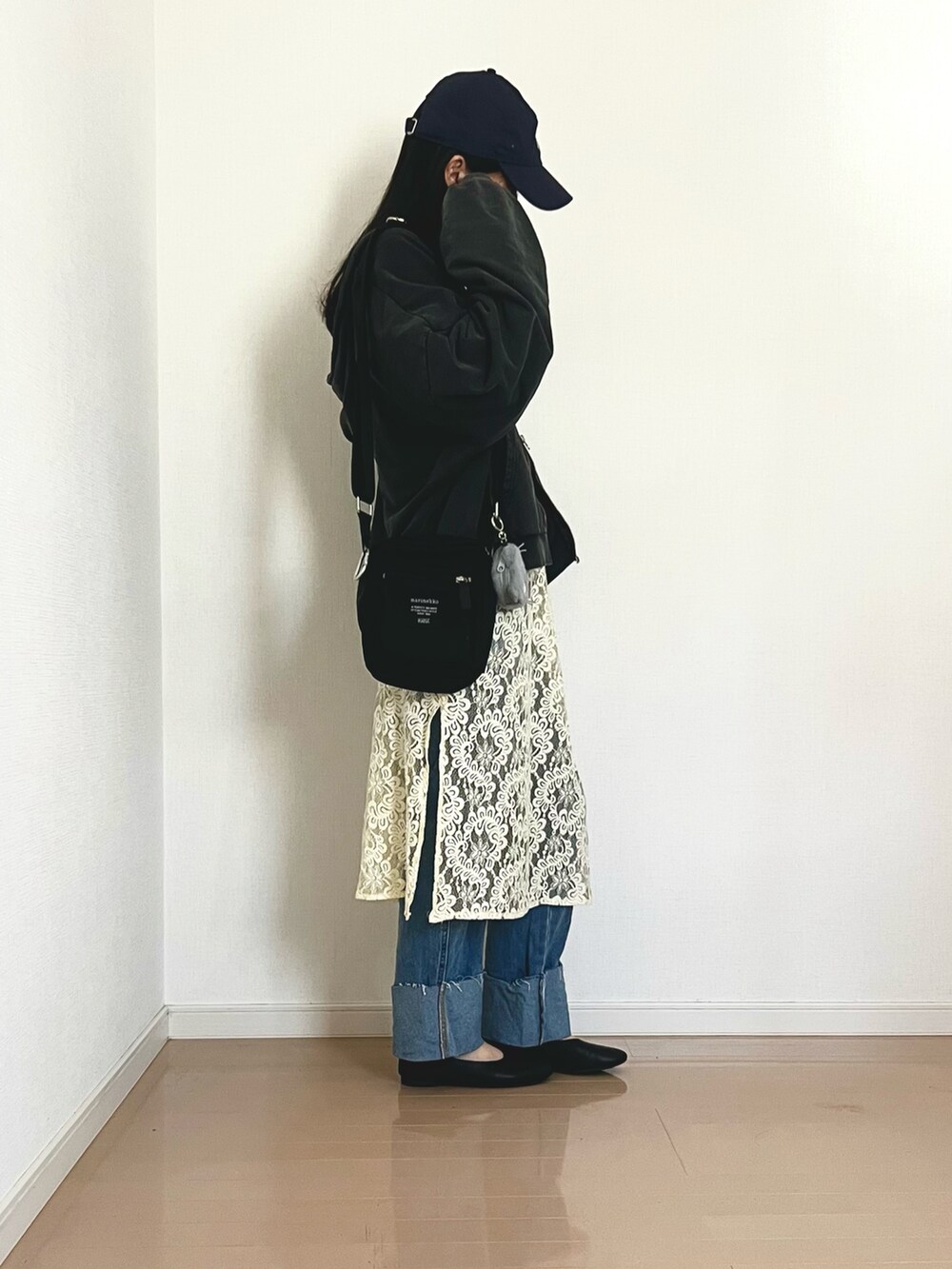 ブラック系のパーカー、ブルー系のデニムパンツ、ホワイト系のキャミソールを着用したレディースの春コーディネートの3枚目の写真