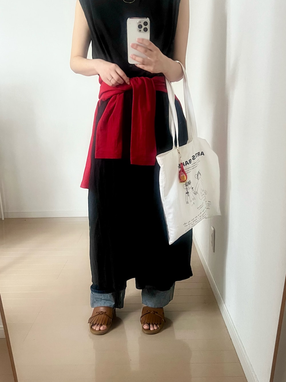 ブルー系のデニムパンツ、レッド系のカーディガン/ボレロ、ブラウン系のサンダルを着用したレディースの春コーディネートの2枚目の写真