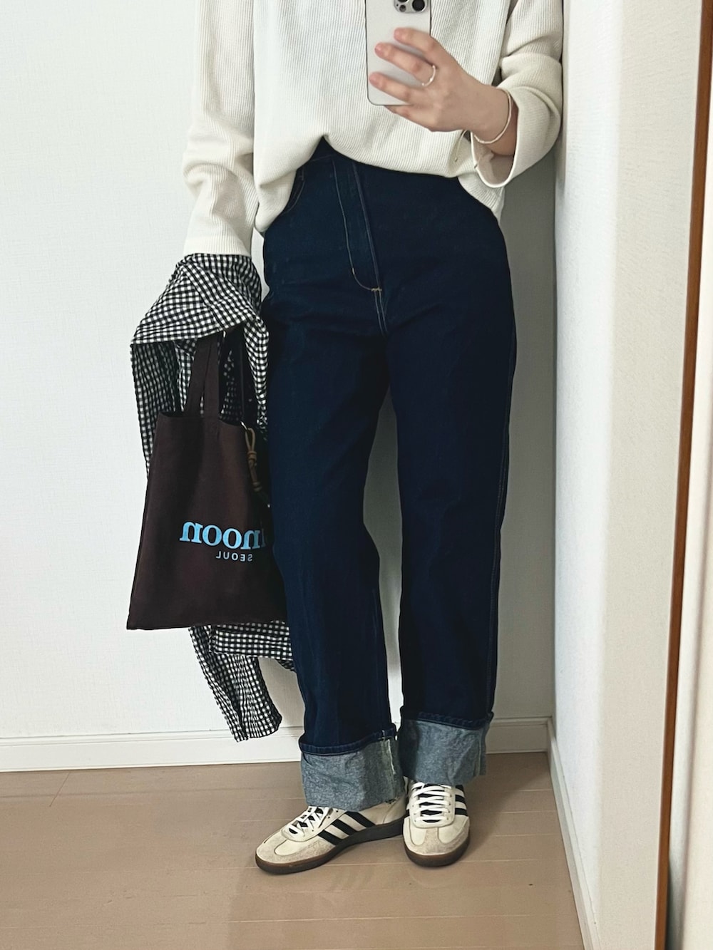 ホワイト系のTシャツ/カットソー、ブルー系のデニムパンツ、ホワイト系のスニーカーを着用したレディースの春コーディネートの2枚目の写真
