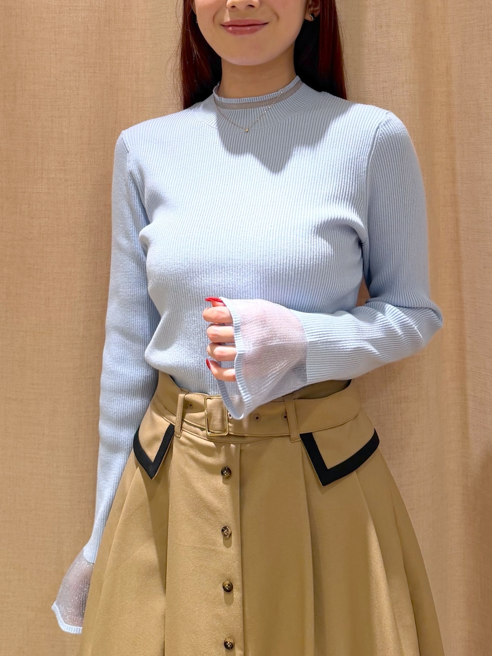 ベージュ系のスカート、ブルー系のニット/セーター、イエロー系のトートバッグを着用したレディースの秋コーディネートの7枚目の写真