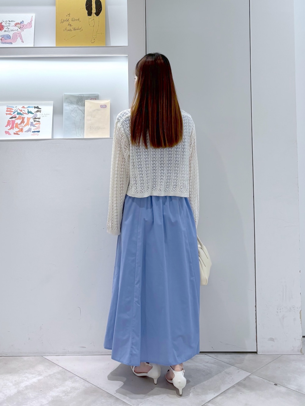 ホワイト系のカーディガン/ボレロ、ホワイト系のボストンバッグ、ブルー系のワンピースを着用したレディースの夏コーディネートの4枚目の写真
