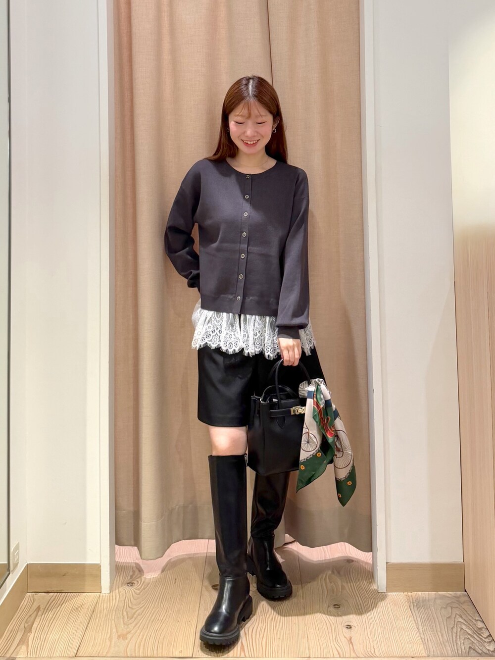 ブラウン系のトレンチコート、ブラック系のブーツ、グレー系のニット/セーターを着用したレディースの秋コーディネートの6枚目の写真