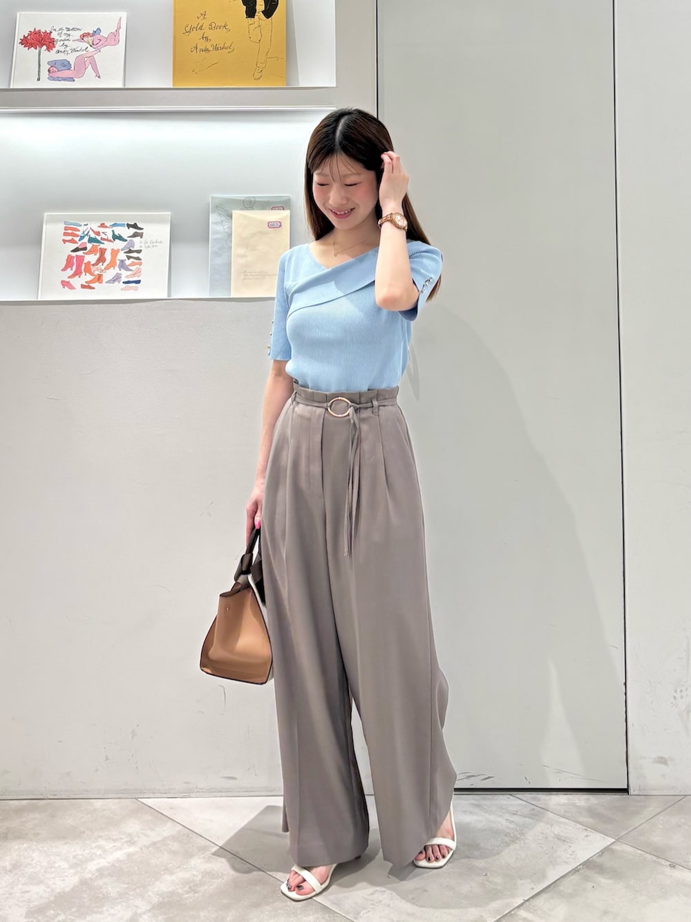 ブラウン系のその他パンツ、ホワイト系のトートバッグ、ブルー系のニット/セーターを着用したレディースの春コーディネートの3枚目の写真