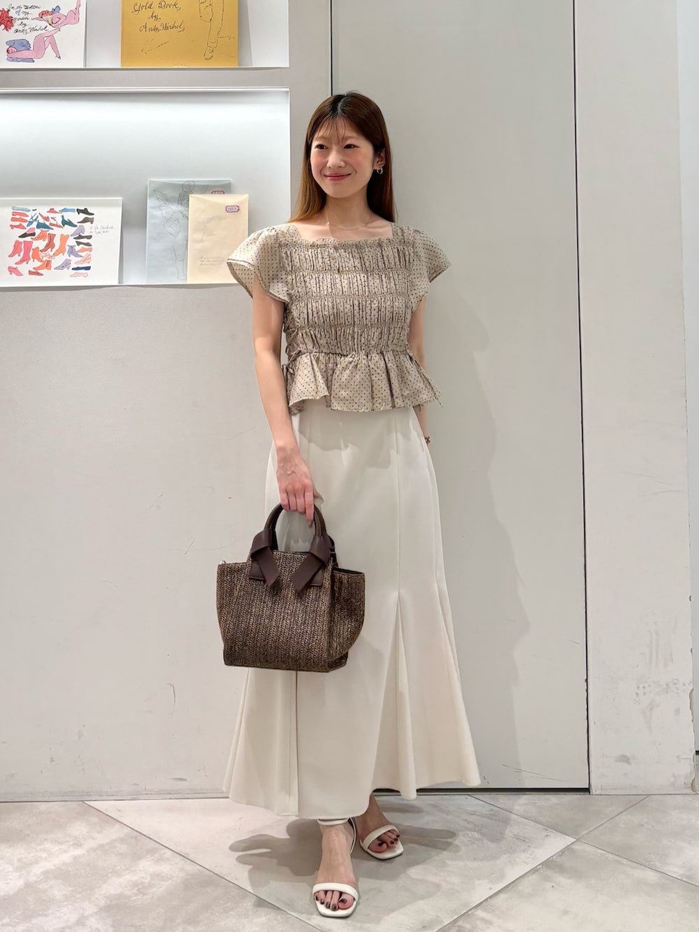ホワイト系のスカート、ブラウン系のトートバッグ、ベージュ系のシャツ/ブラウスを着用したレディースの夏コーディネートの2枚目の写真
