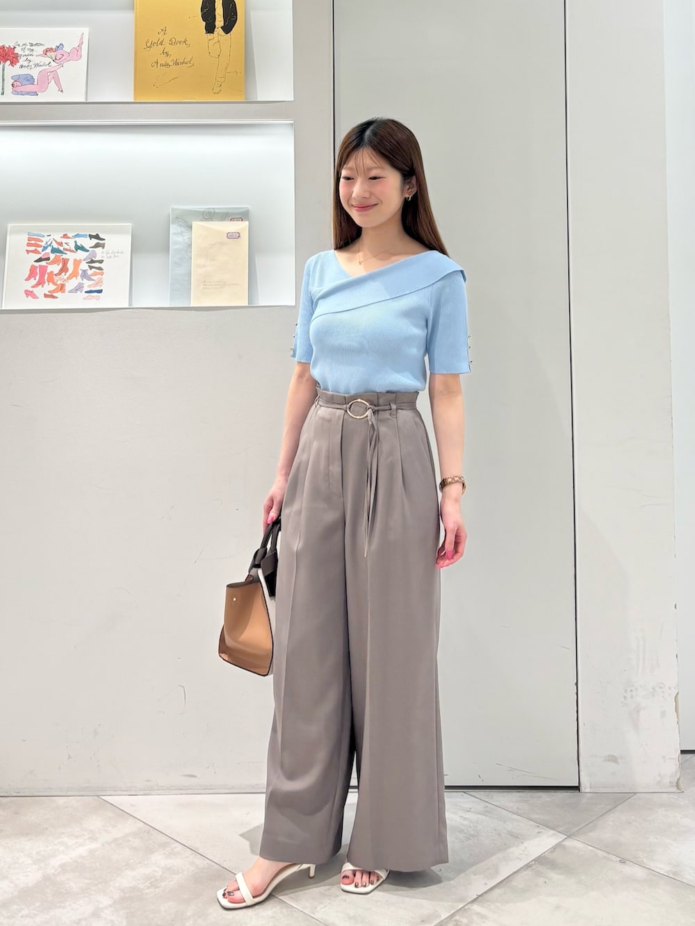ブラウン系のその他パンツ、ホワイト系のトートバッグ、ブルー系のニット/セーターを着用したレディースの春コーディネートの4枚目の写真