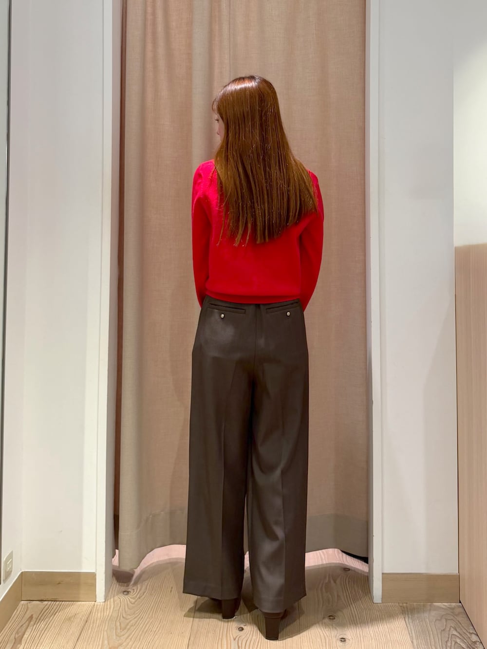 ブラウン系のその他パンツ、レッド系のニット/セーター、ブラウン系のボストンバッグを着用したレディースの秋コーディネートの6枚目の写真