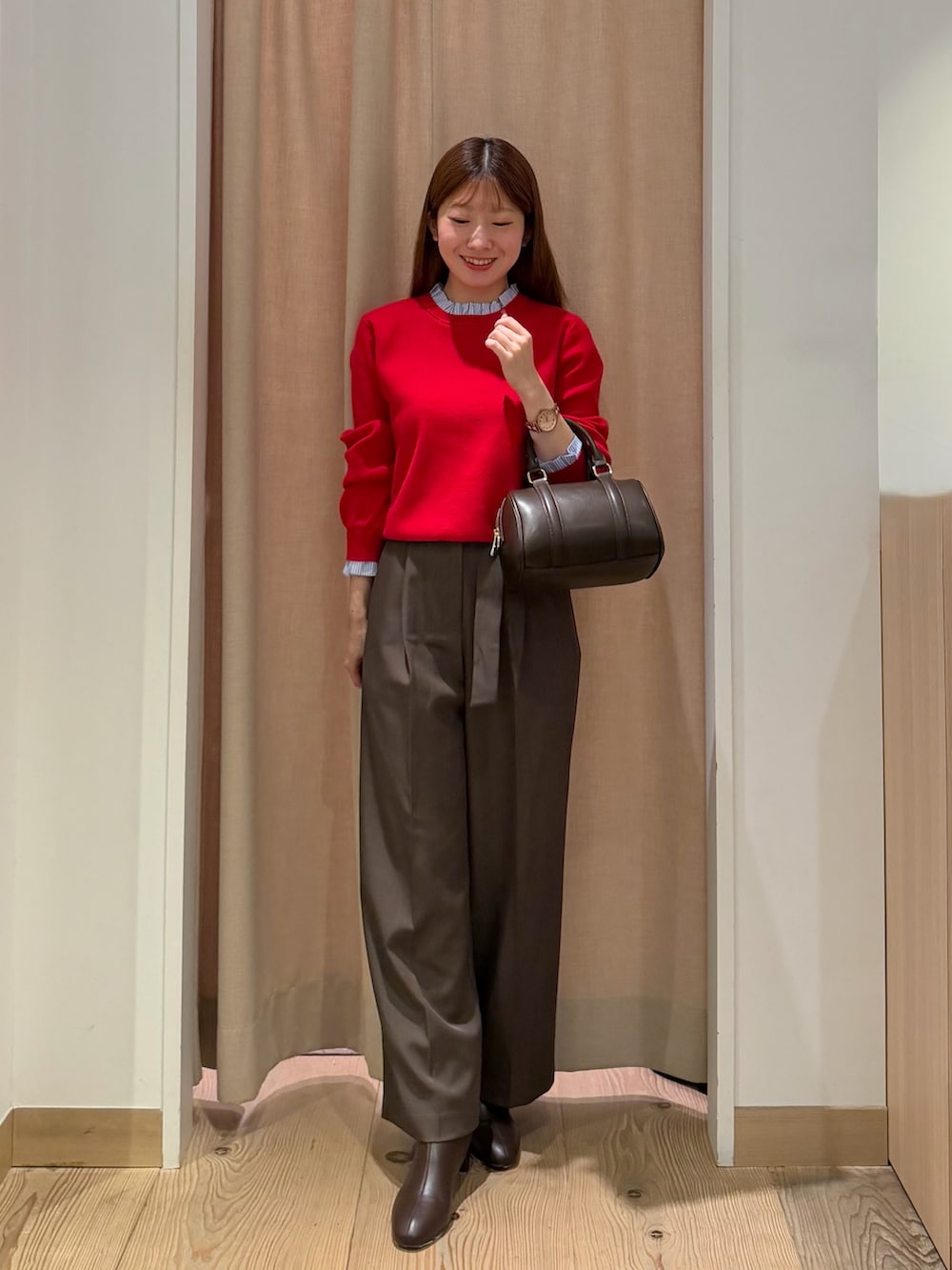 ブラウン系のその他パンツ、レッド系のニット/セーター、ブラウン系のボストンバッグを着用したレディースの秋コーディネートの3枚目の写真