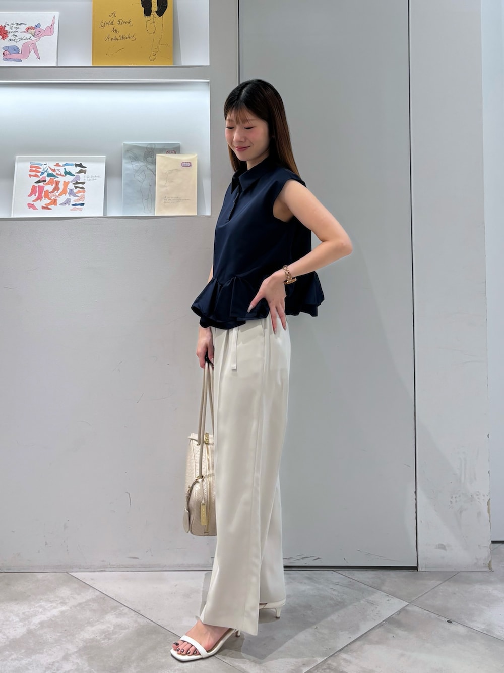 ブルー系のシャツ/ブラウス、ベージュ系のその他パンツ、ホワイト系のボストンバッグを着用したレディースの夏コーディネートの3枚目の写真
