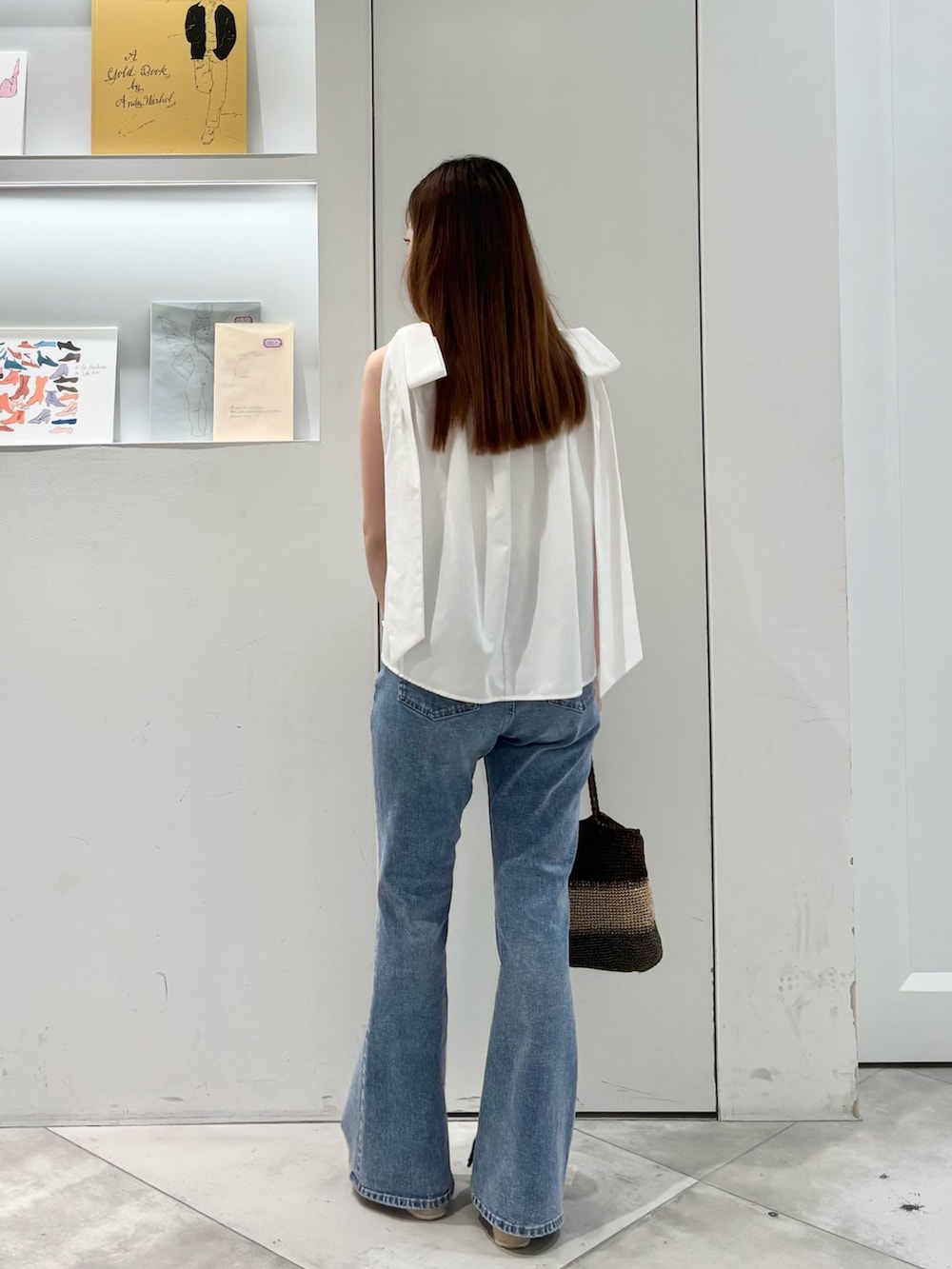 ホワイト系のシャツ/ブラウス、ゴールド系のハンドバッグ、ブルー系のデニムパンツを着用したレディースの夏コーディネートの6枚目の写真