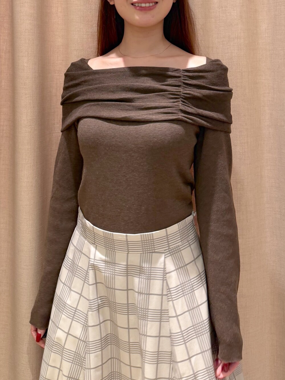 ベージュ系のスカート、ホワイト系のトートバッグ、ブラウン系のニット/セーターを着用したレディースの秋コーディネートの7枚目の写真