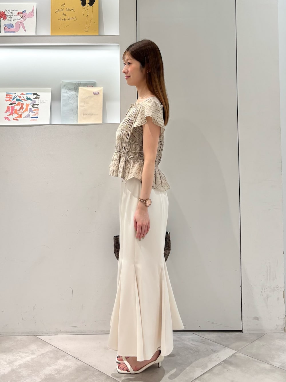 ホワイト系のスカート、ブラウン系のトートバッグ、ベージュ系のシャツ/ブラウスを着用したレディースの夏コーディネートの3枚目の写真