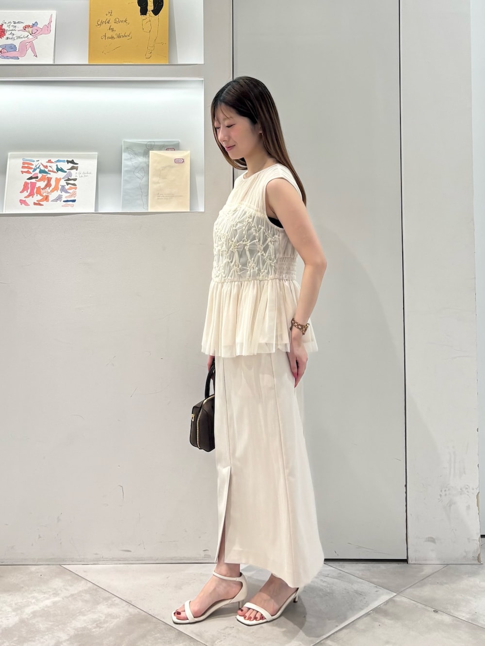 ホワイト系のシャツ/ブラウス、ホワイト系のスカート、ブラウン系のボストンバッグを着用したレディースの春コーディネートの3枚目の写真