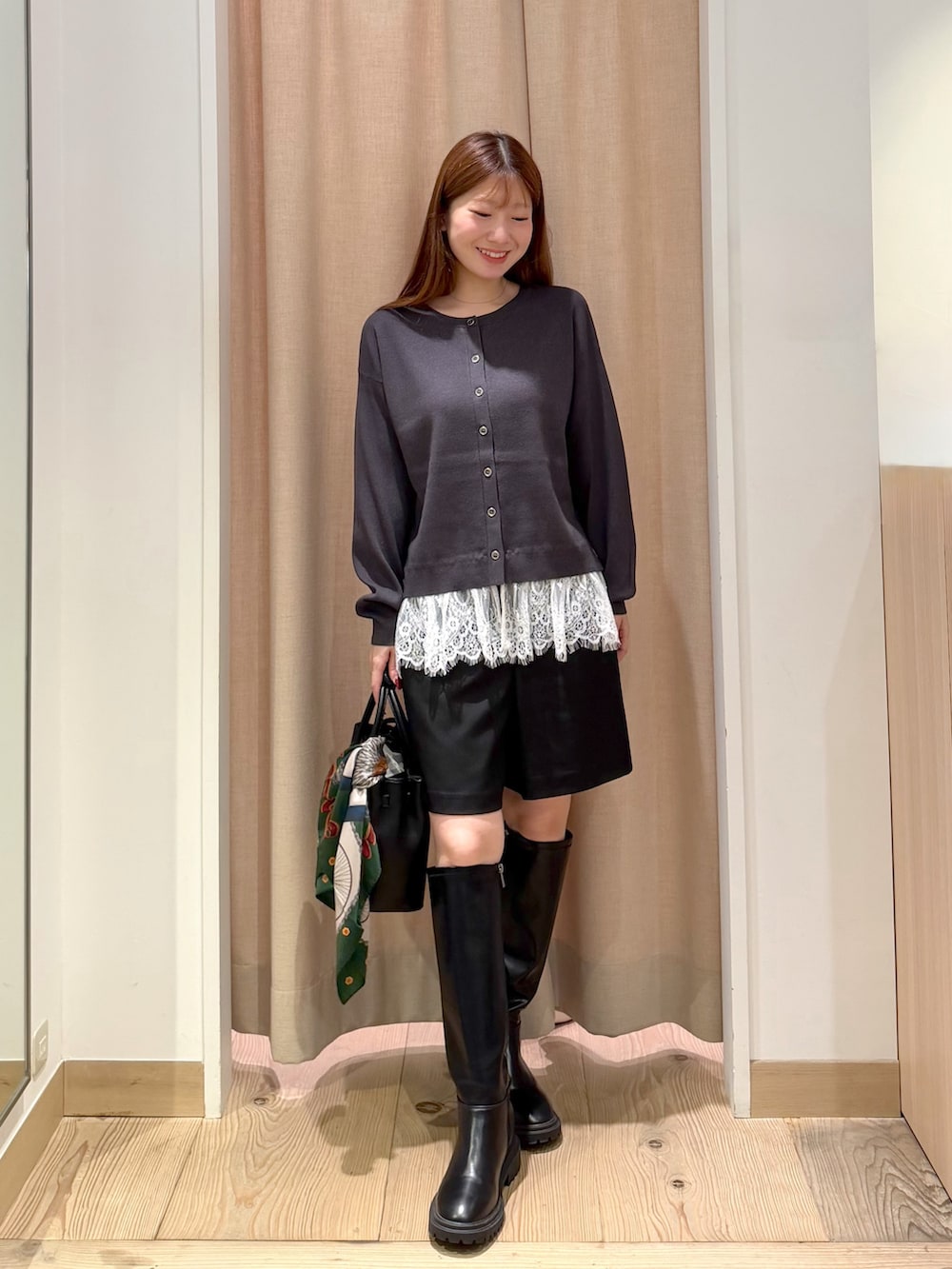 ブラウン系のトレンチコート、ブラック系のブーツ、グレー系のニット/セーターを着用したレディースの秋コーディネートの5枚目の写真