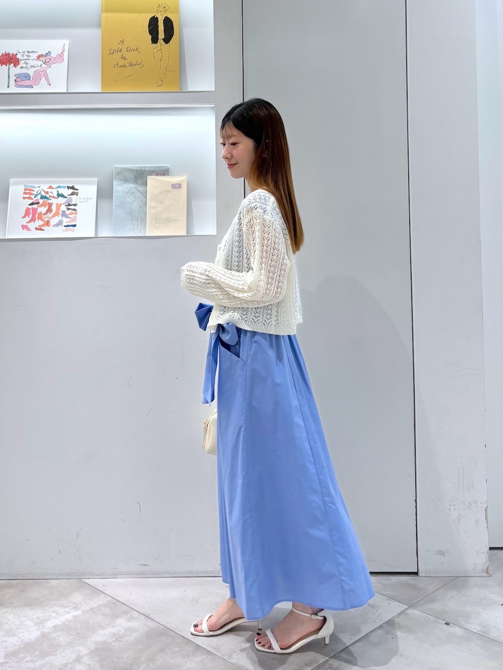 ホワイト系のカーディガン/ボレロ、ホワイト系のボストンバッグ、ブルー系のワンピースを着用したレディースの夏コーディネートの3枚目の写真