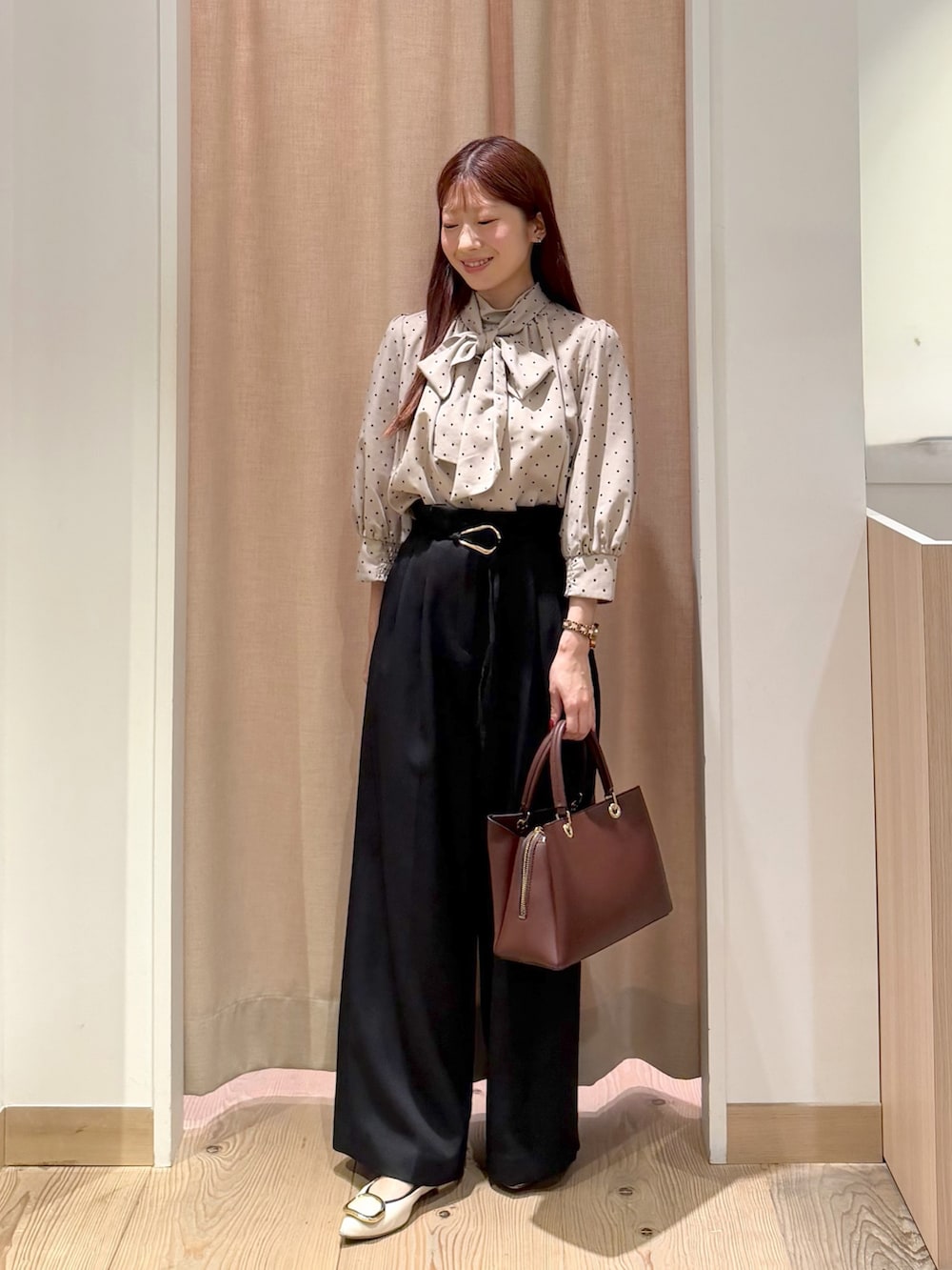 ブラウン系のテーラードジャケット、ベージュ系のシャツ/ブラウス、レッド系のトートバッグを着用したレディースの秋コーディネートの3枚目の写真