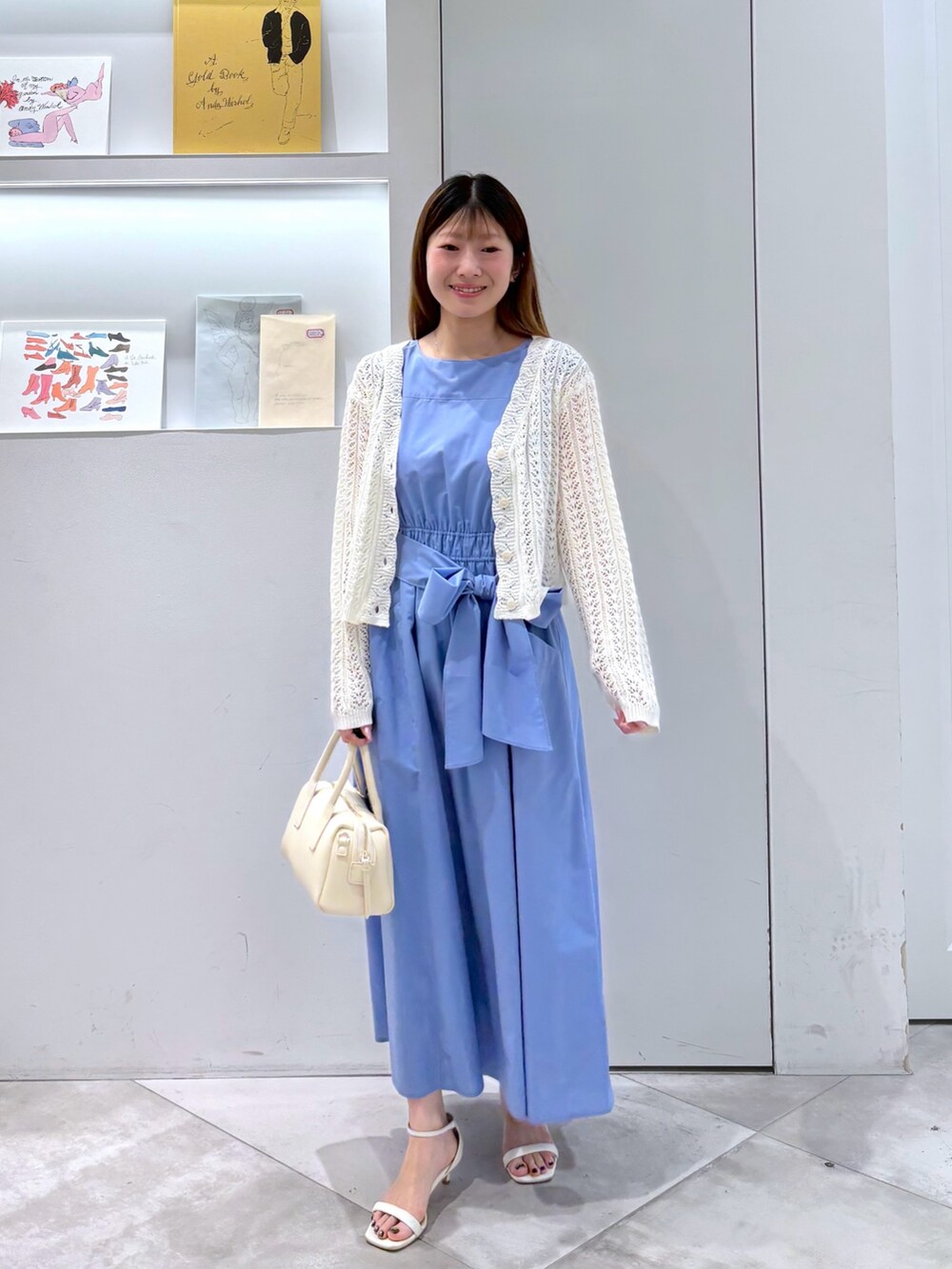 ホワイト系のカーディガン/ボレロ、ホワイト系のボストンバッグ、ブルー系のワンピースを着用したレディースの夏コーディネートの2枚目の写真