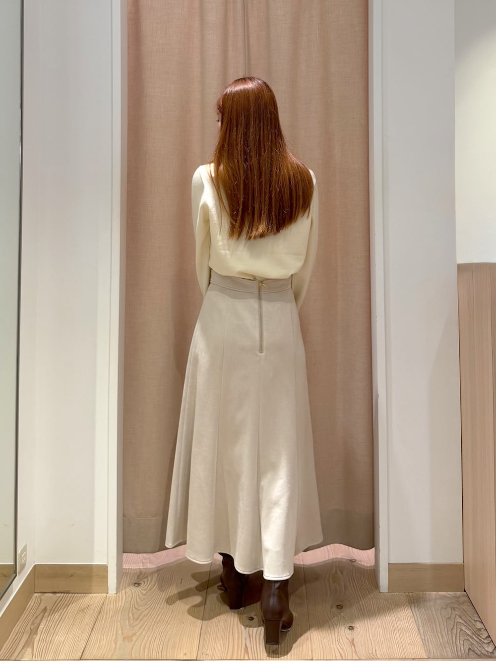 ホワイト系のカーディガン/ボレロ、ブラウン系のボストンバッグ、ベージュ系のスカートを着用したレディースの秋コーディネートの6枚目の写真