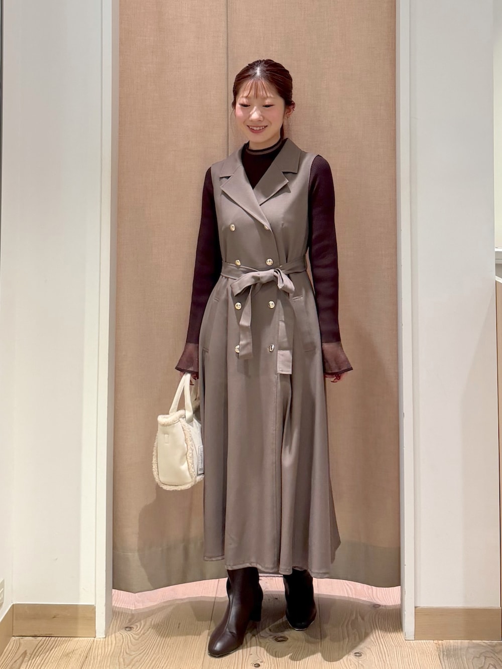 ブラウン系のワンピース、ブラウン系のニット/セーター、ホワイト系のトートバッグを着用したレディースの秋コーディネートの3枚目の写真