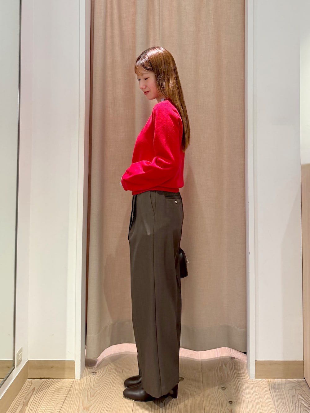 ブラウン系のその他パンツ、レッド系のニット/セーター、ブラウン系のボストンバッグを着用したレディースの秋コーディネートの5枚目の写真