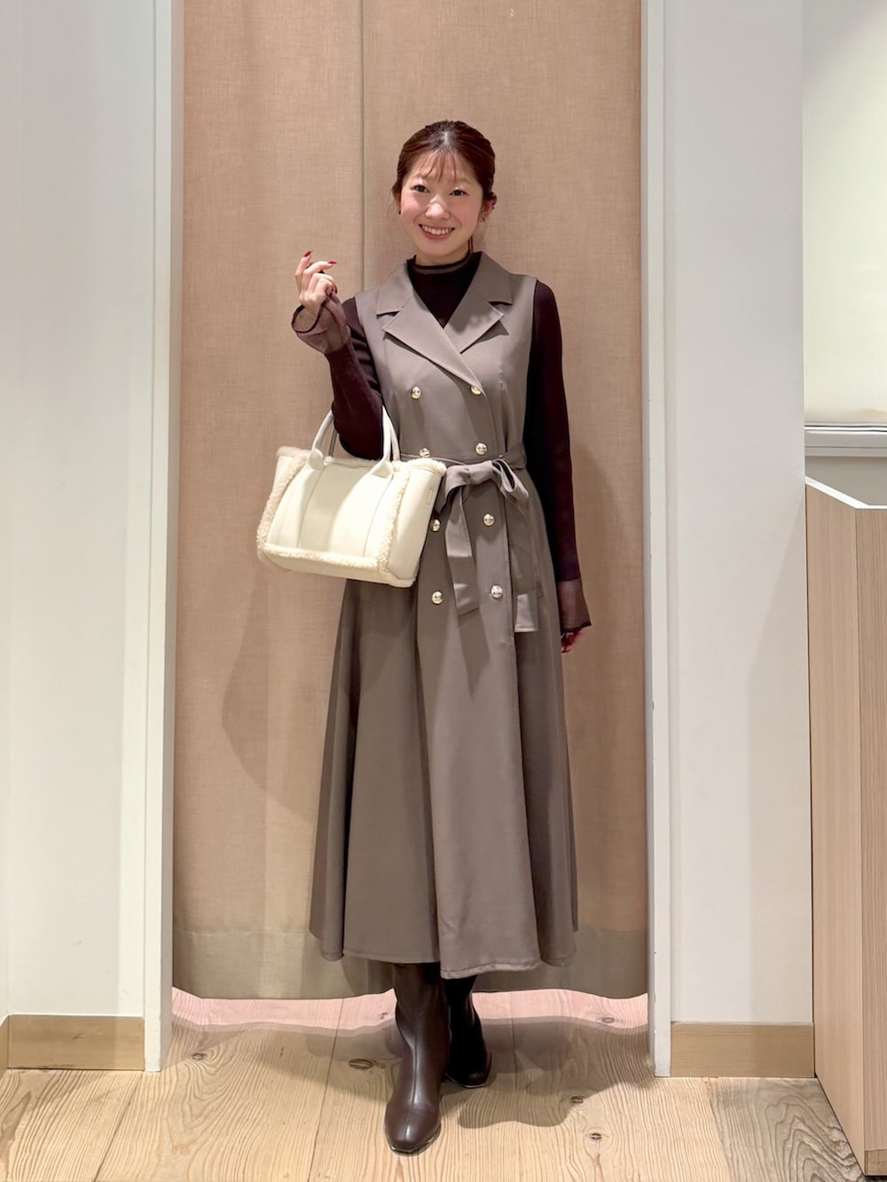 ブラウン系のワンピース、ブラウン系のニット/セーター、ホワイト系のトートバッグを着用したレディースの秋コーディネートの2枚目の写真