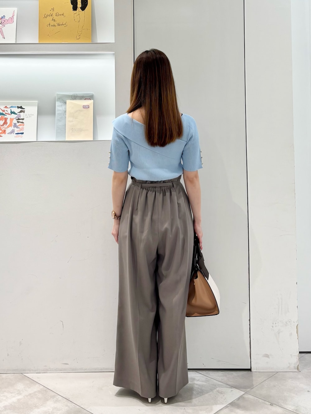 ブラウン系のその他パンツ、ホワイト系のトートバッグ、ブルー系のニット/セーターを着用したレディースの春コーディネートの7枚目の写真