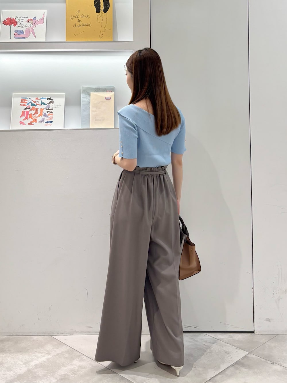 ブラウン系のその他パンツ、ホワイト系のトートバッグ、ブルー系のニット/セーターを着用したレディースの春コーディネートの6枚目の写真
