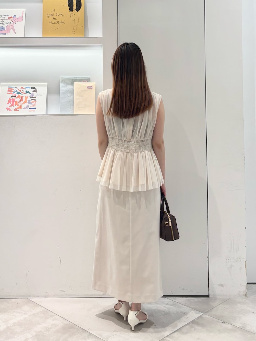 ホワイト系のシャツ/ブラウス、ホワイト系のスカート、ブラウン系のボストンバッグを着用したレディースの春コーディネートの5枚目の写真