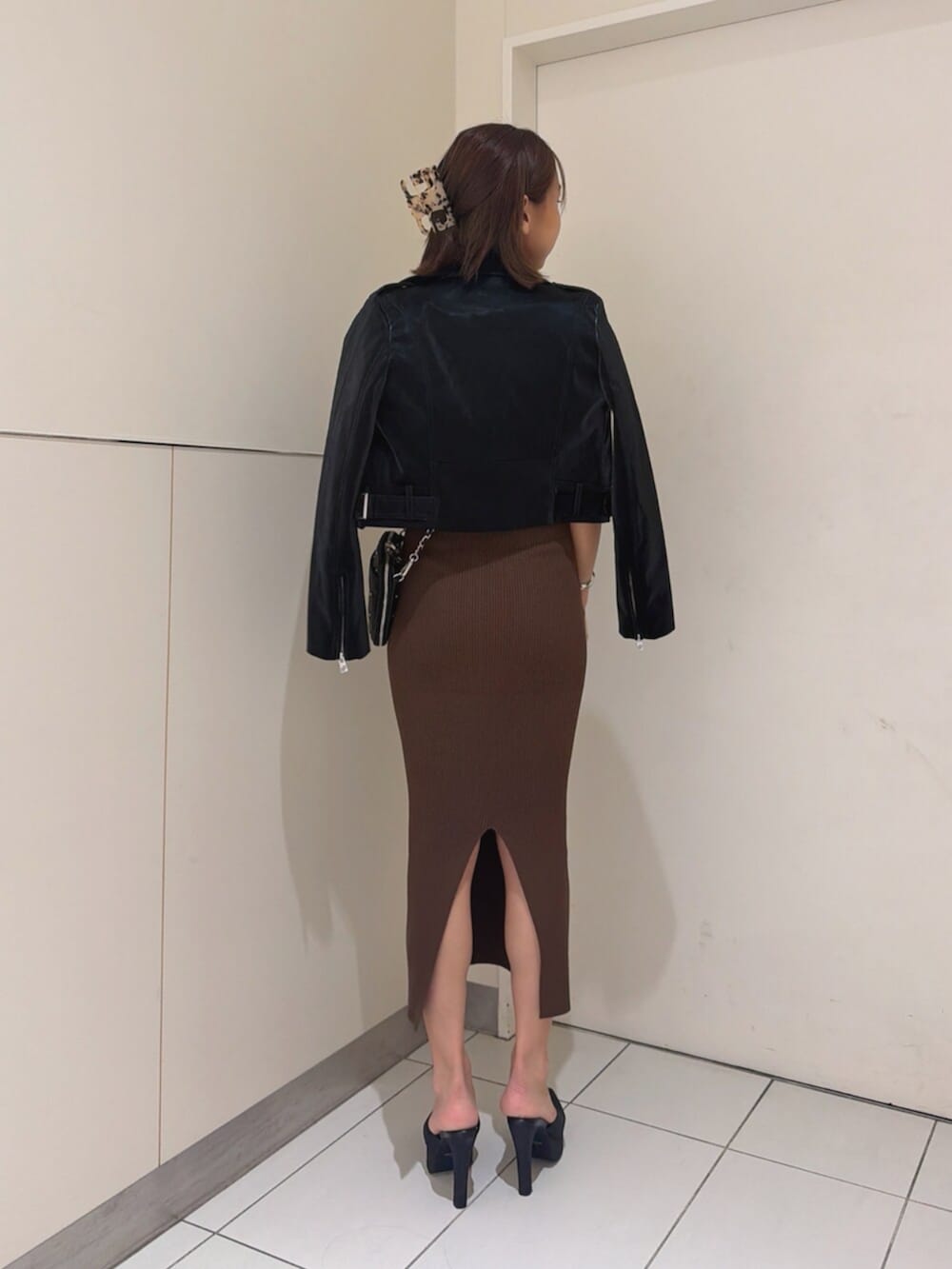 ブラック系のショルダーバッグ、ブラック系のパンプス、ブラウン系のワンピースを着用したレディースの秋コーディネートの3枚目の写真