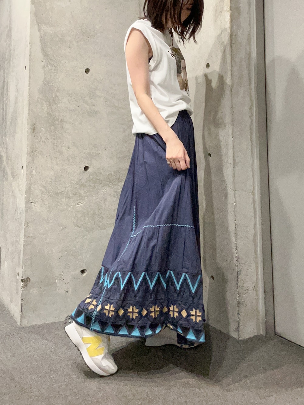 ホワイト系のTシャツ/カットソー、ブルー系のスカート、ホワイト系のスニーカーを着用したレディースの夏コーディネートの2枚目の写真