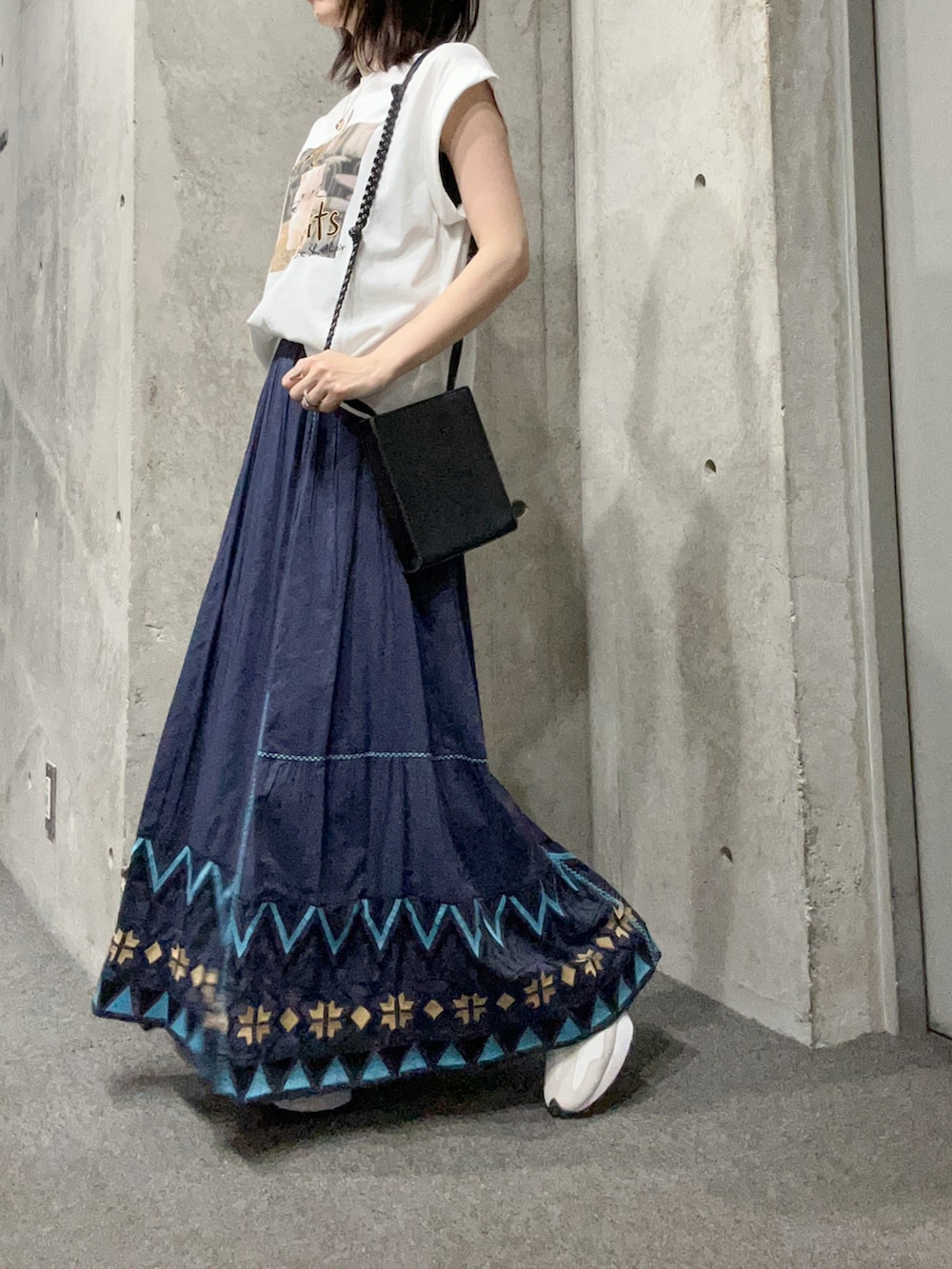 ホワイト系のTシャツ/カットソー、ブルー系のスカート、ホワイト系のスニーカーを着用したレディースの夏コーディネートの4枚目の写真