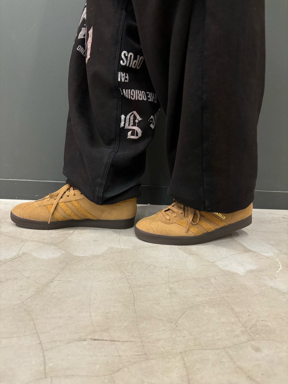 ブラック系のジャージ、ブラウン系のスニーカーを着用したメンズの秋コーディネートの2枚目の写真