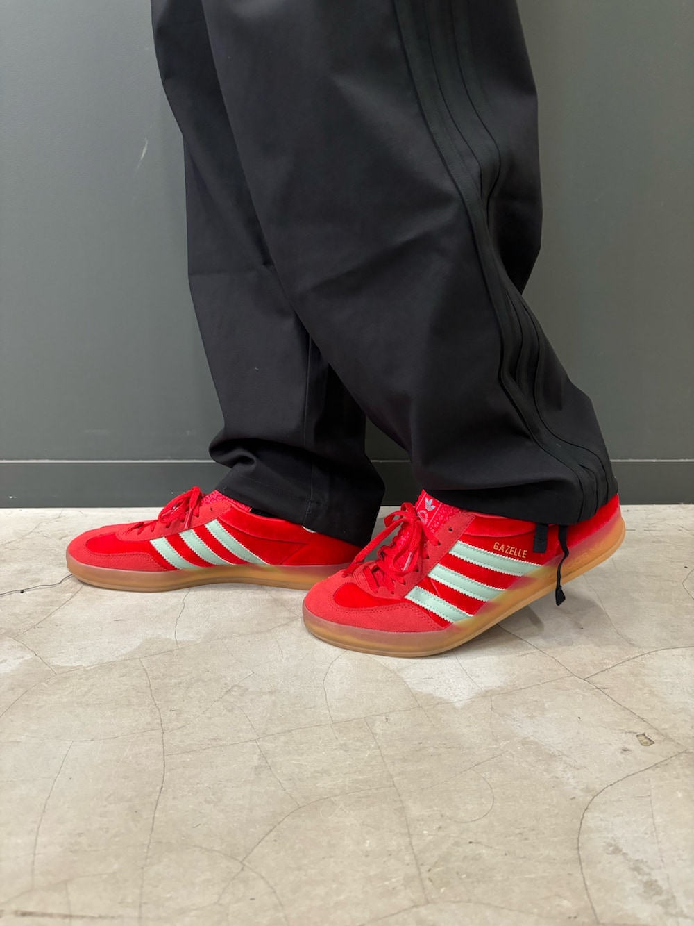 ブラック系のナイロンジャケット、ブラック系のスウェットパンツ、レッド系のスニーカーを着用したメンズの秋コーディネートの2枚目の写真