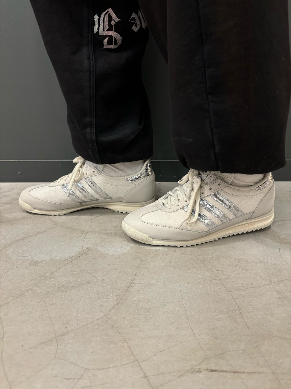 ホワイト系のポロシャツ、グレー系のシューズ、ブルー系のストール/ショールを着用したメンズの秋コーディネートの2枚目の写真