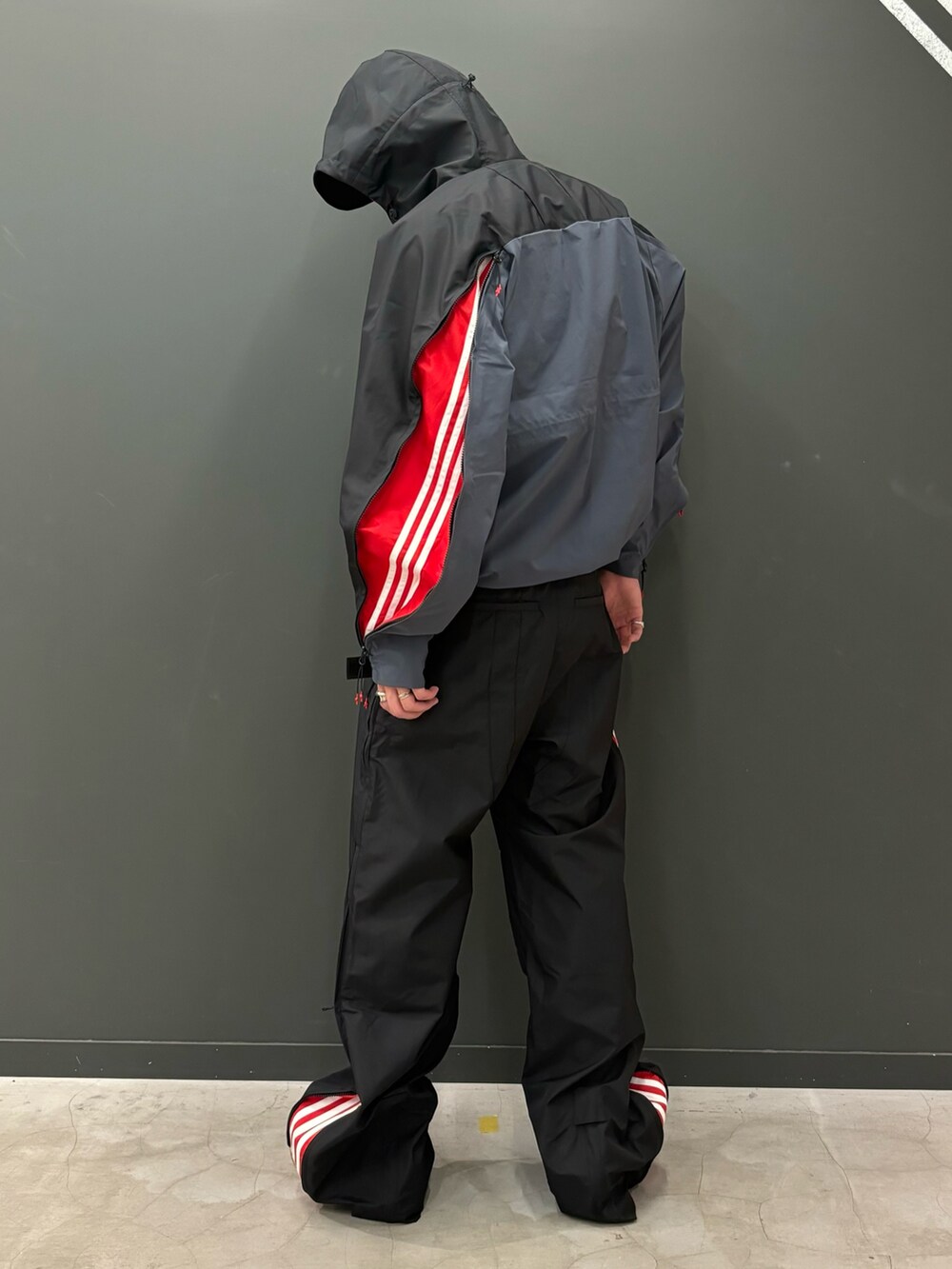 ブラック系のジャケット/アウター、ブラック系のパンツ、レッド系のスニーカーを着用したメンズの秋コーディネートの2枚目の写真