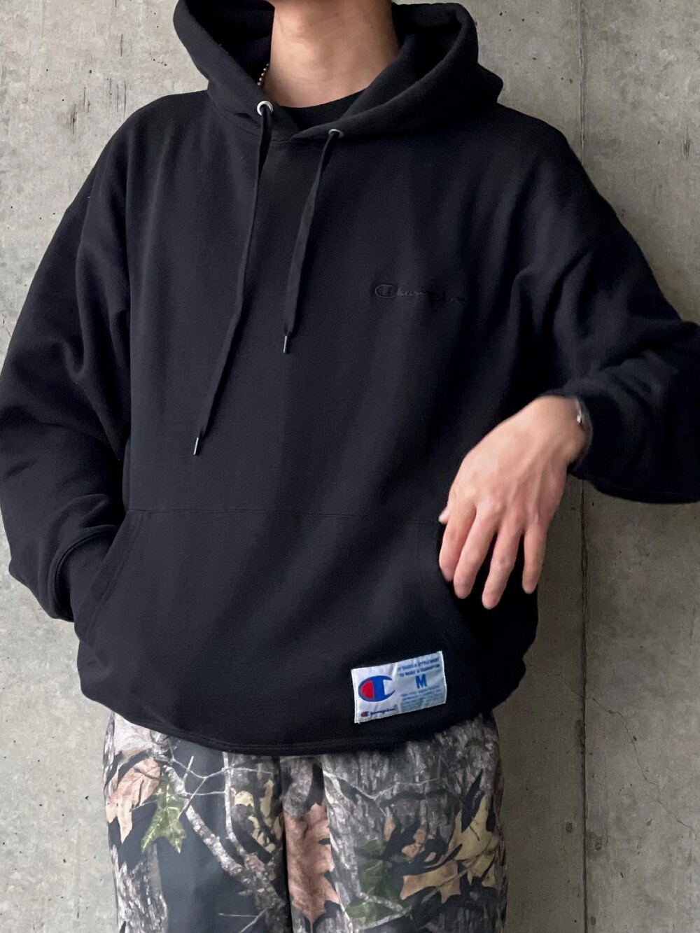 ブラウン系のスラックス、ブラック系のパーカーを着用したメンズの春コーディネートの4枚目の写真