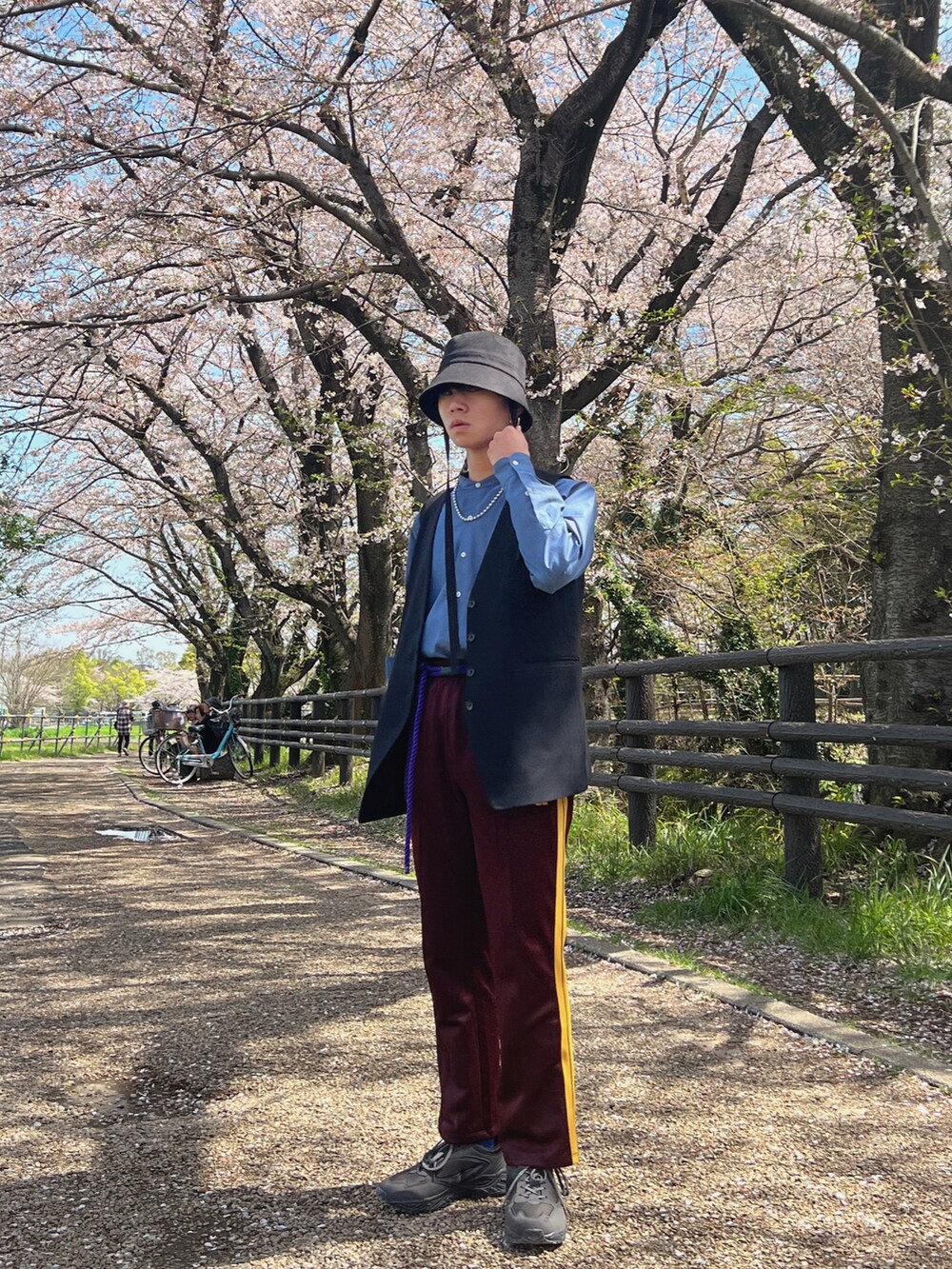 ベージュ系のスニーカー、ブラック系のハットを着用したメンズの春コーディネートの2枚目の写真