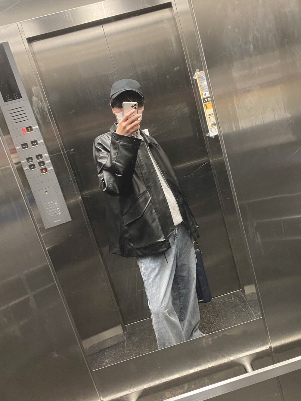 ブラック系のブルゾン、グレー系のニット/セーター、ブルー系のスラックスを着用したメンズの秋コーディネートの2枚目の写真