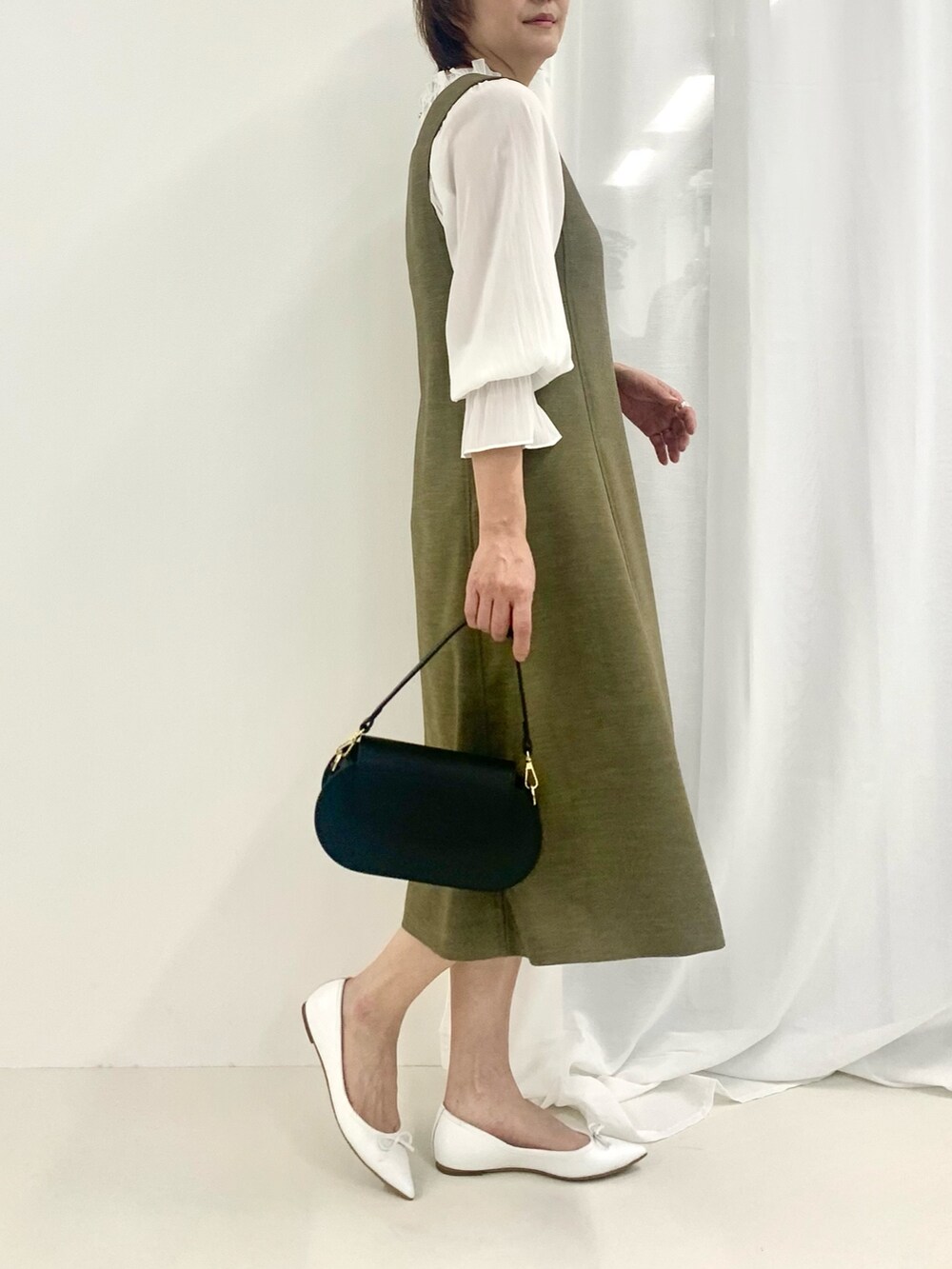 グリーン系のワンピース、ホワイト系のシャツ/ブラウス、ブラック系のショルダーバッグを着用したレディースの春コーディネートの4枚目の写真
