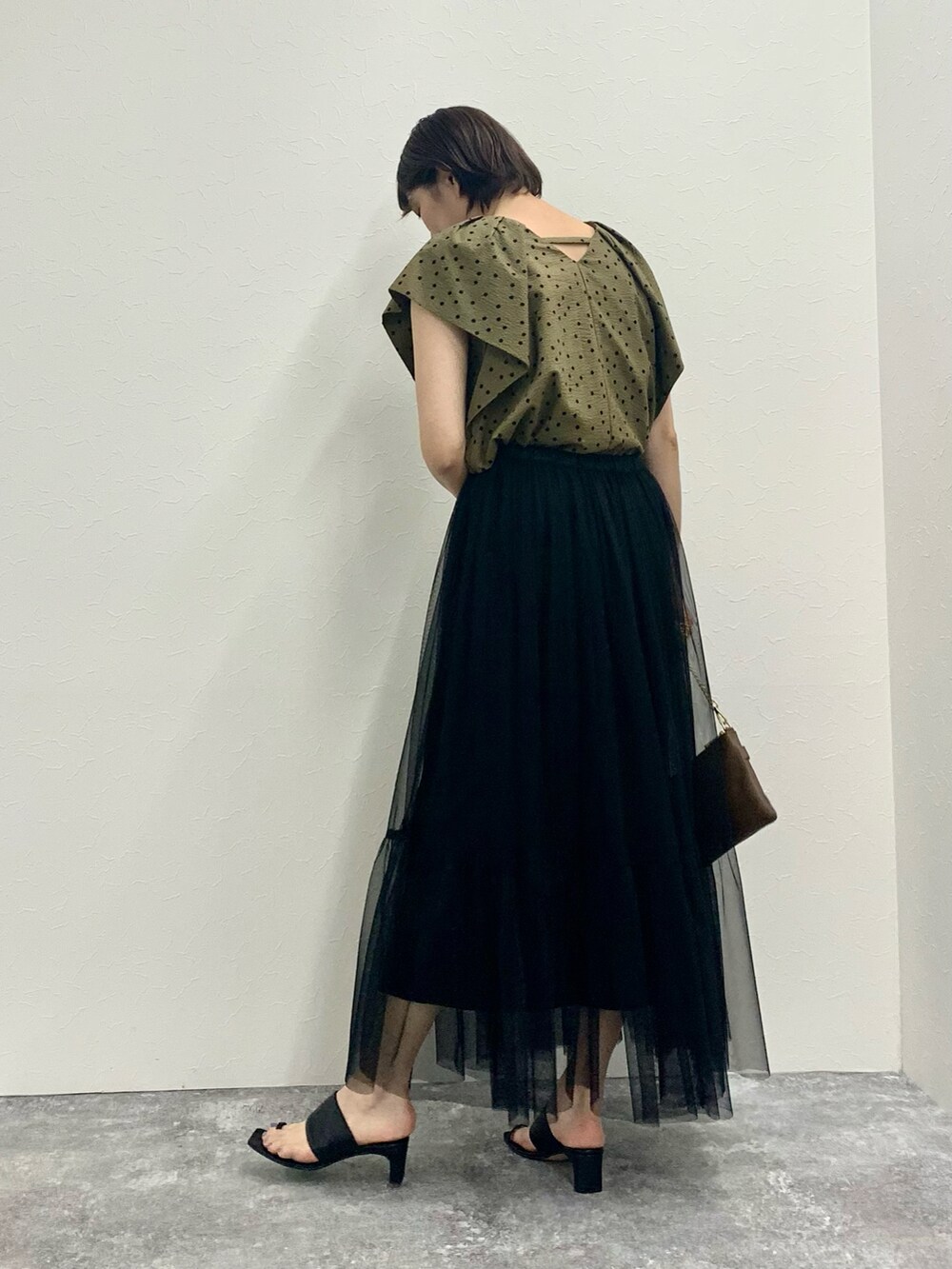 グリーン系のシャツ/ブラウス、ブラック系のスカート、ベージュ系のショルダーバッグを着用したレディースの夏コーディネートの3枚目の写真