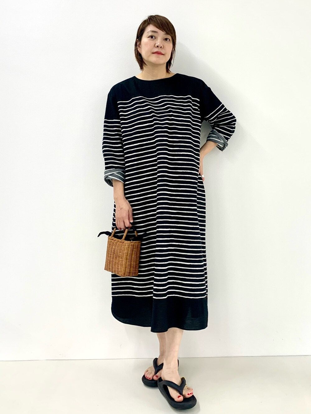 ブラック系のワンピース、グレー系のTシャツ/カットソー、ブラック系のサンダルを着用したレディースの春コーディネートの5枚目の写真