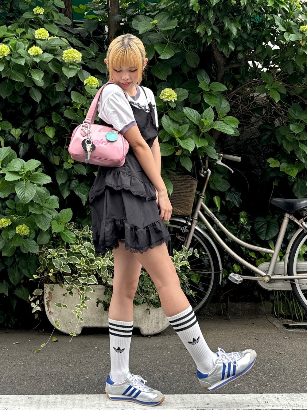 ピンク系のハンドバッグ、ホワイト系のTシャツ/カットソー、ブラック系のワンピースを着用したレディースの夏コーディネートの2枚目の写真